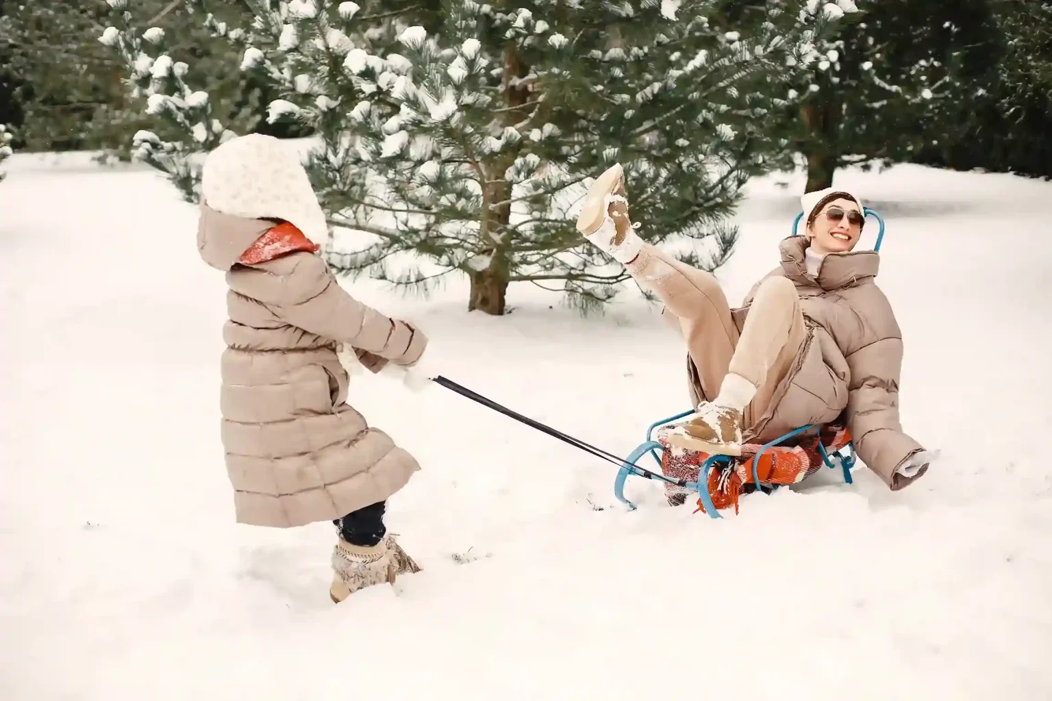 Sledding: children in helmets sliding down a snowy hill on plastic sleds